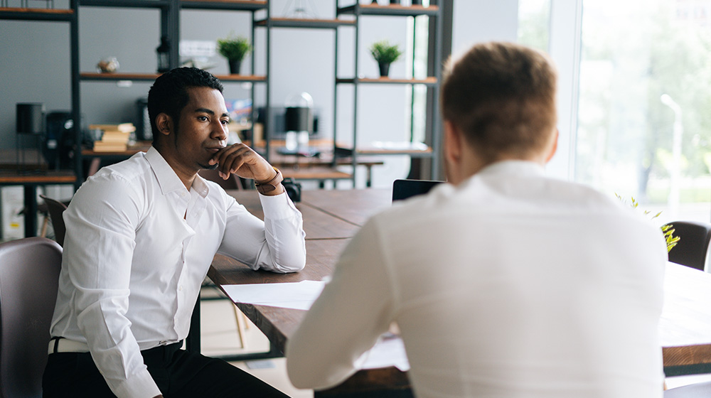 Tax advisor discussing financial strategies and tax planning with a client in an office meeting.