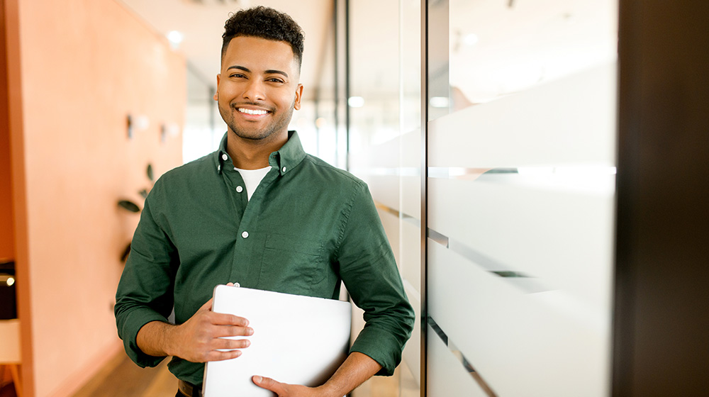 Confident businessman with a laptop, ready to optimize tax strategies for his startup.